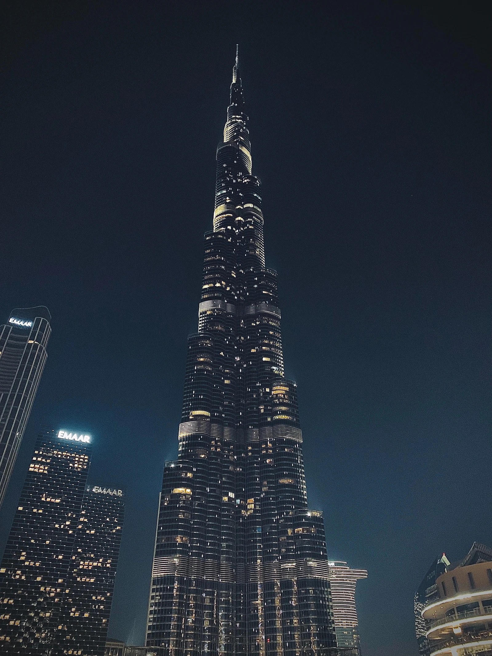 Travel photograph: Burj Khalifa rises brightly illuminated against a dark Dubai night sky.