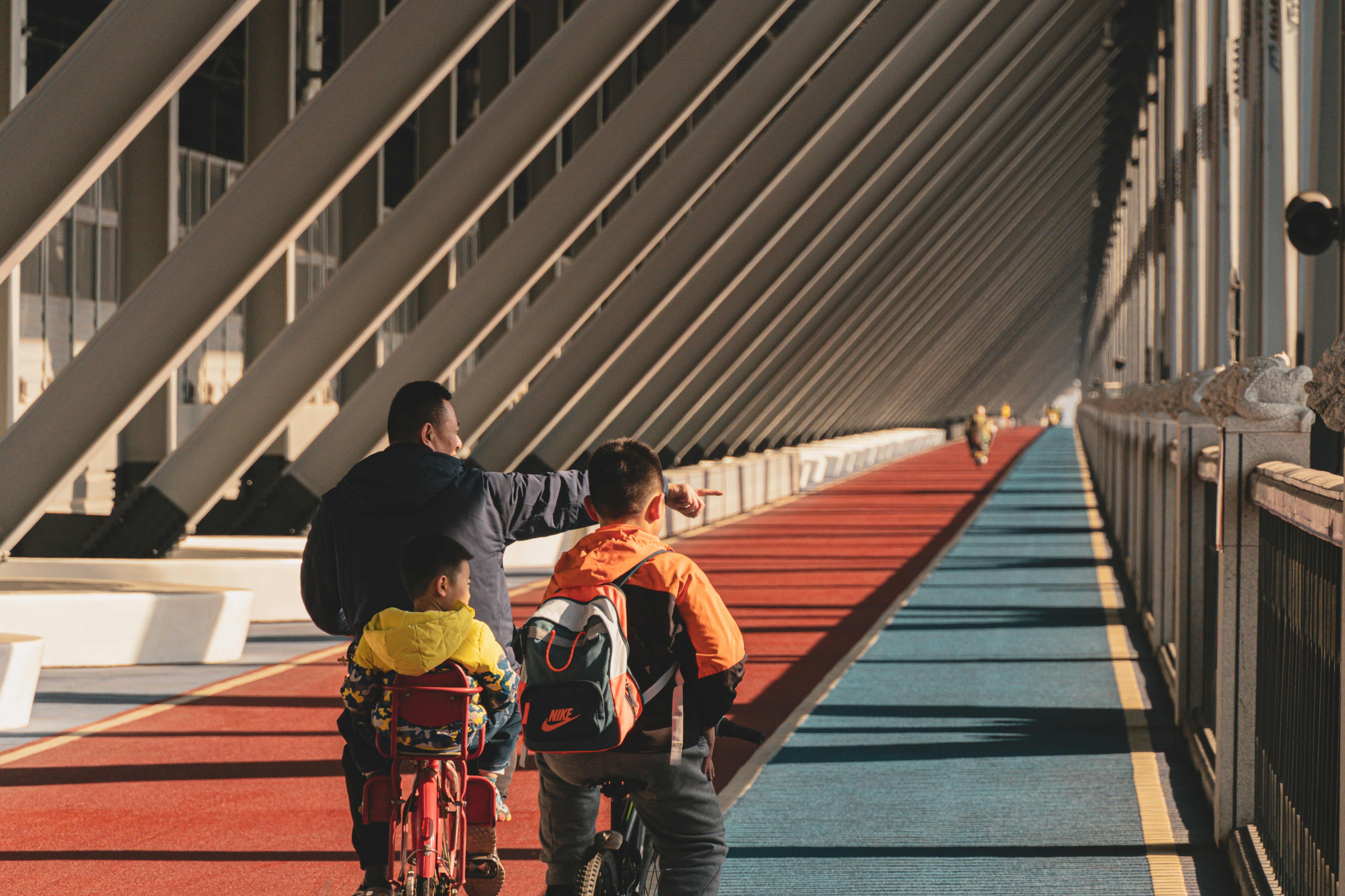 한 가족이 형형색색의 차선이 있는 다리 위에서 자전거를 타고 있습니다.