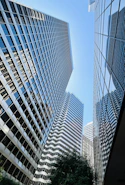 Skyscrapers reach high into a bright blue sky.