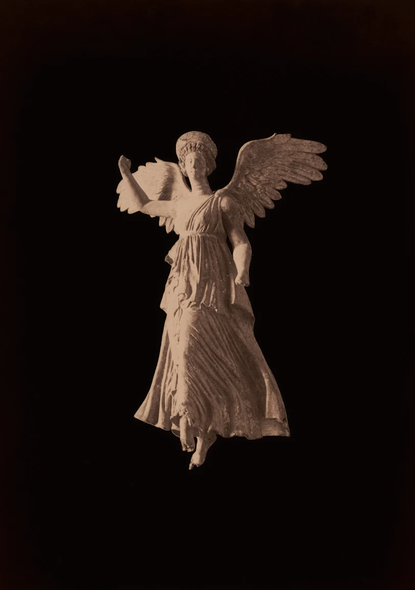 Winged victory statue against a black background.