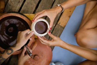 People are sharing a cup of a chocolate drink.