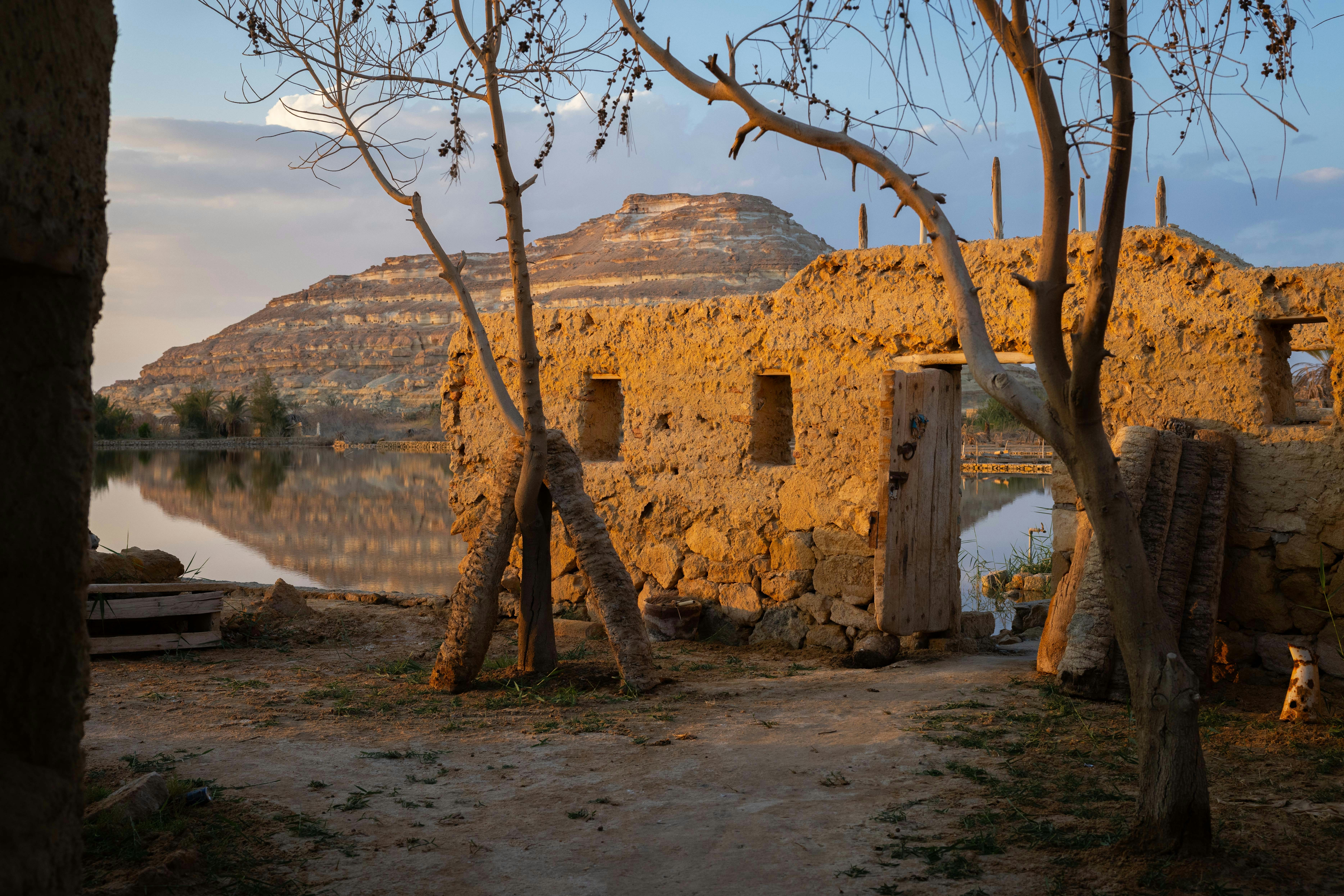 Old structures overlook a calm body of water.