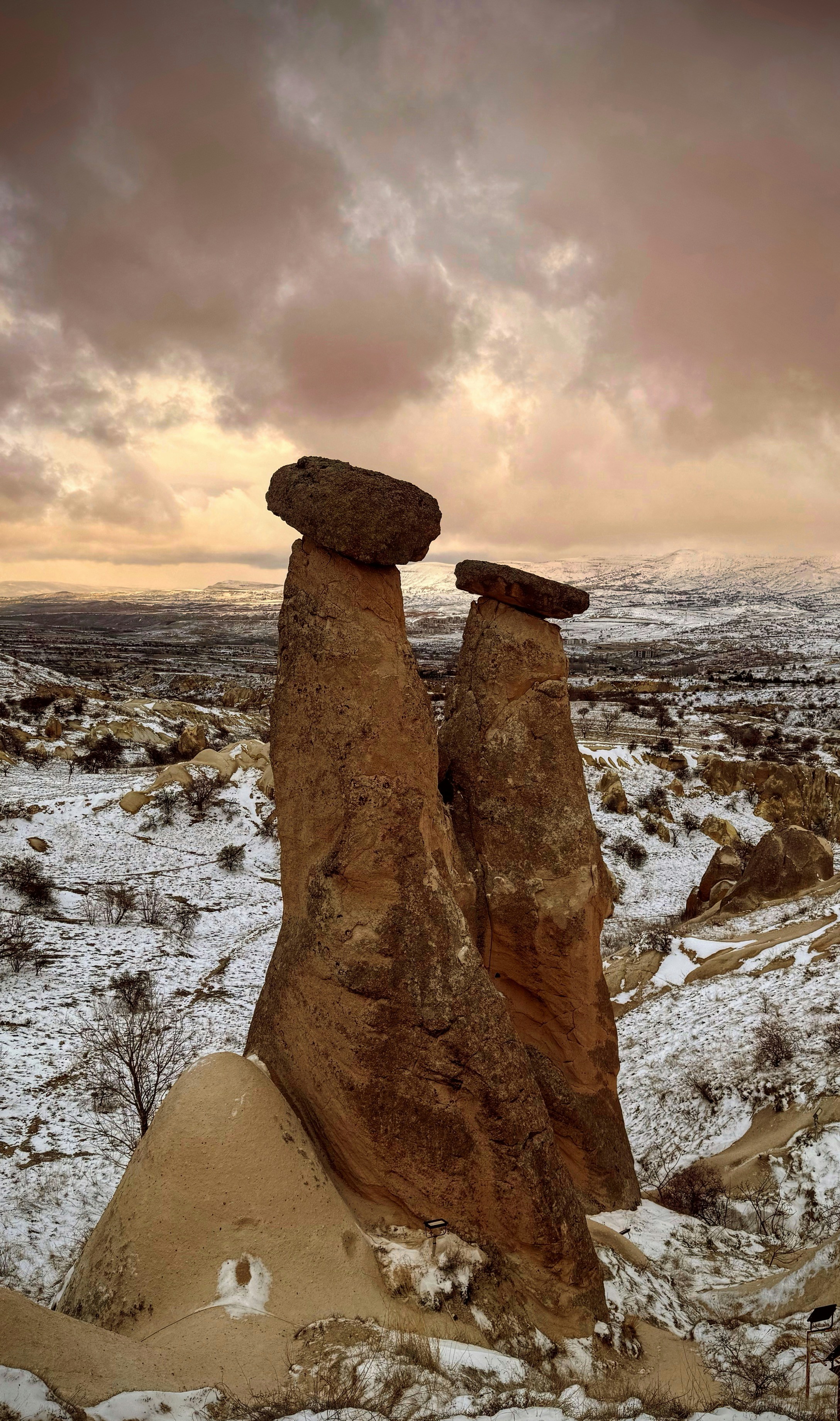 Rock formations sit in a snowy landscape under a cloudy sky - Free ...