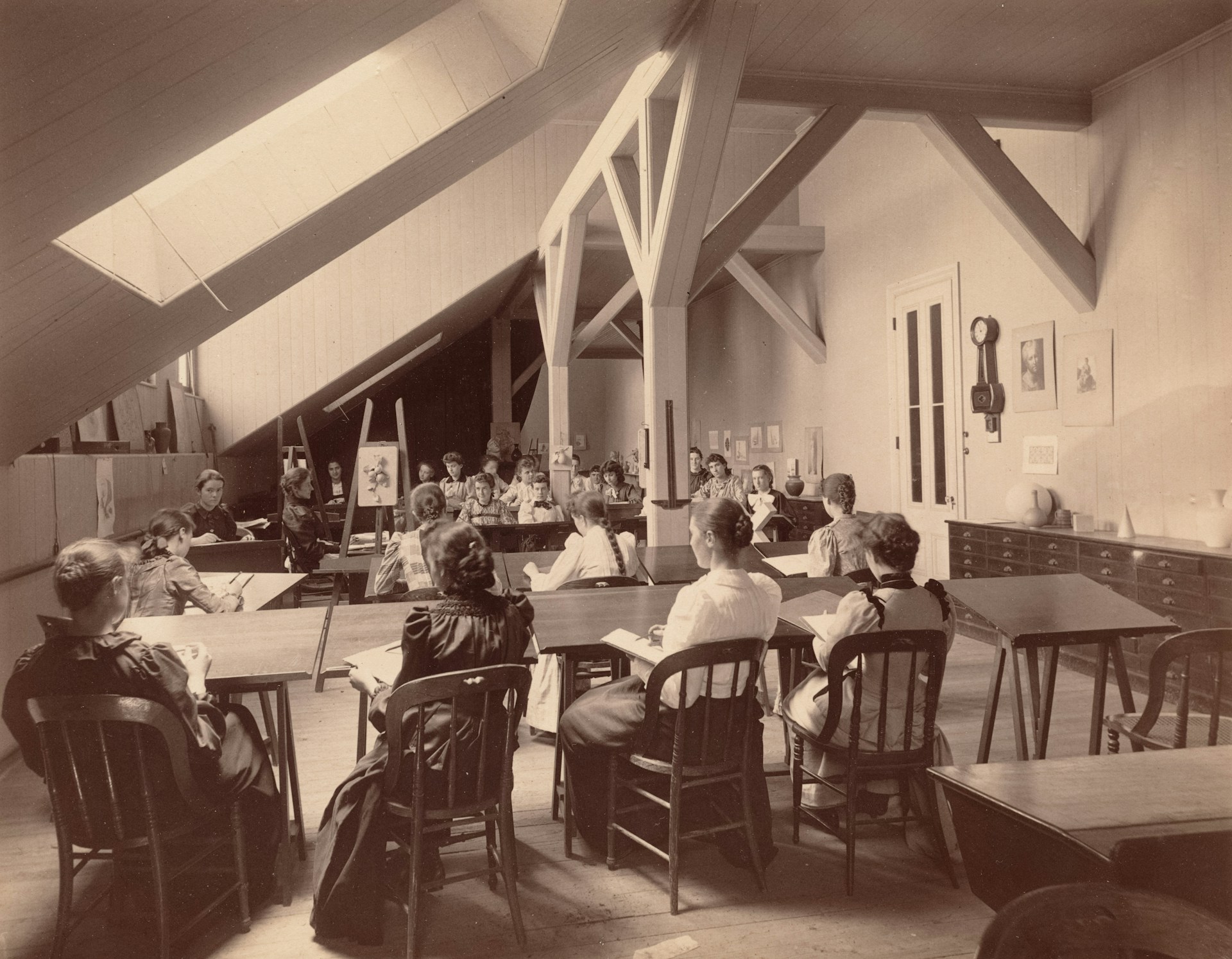 People sit at desks in a classroom.