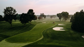 SAGG image of a golf course is surrounded by trees.