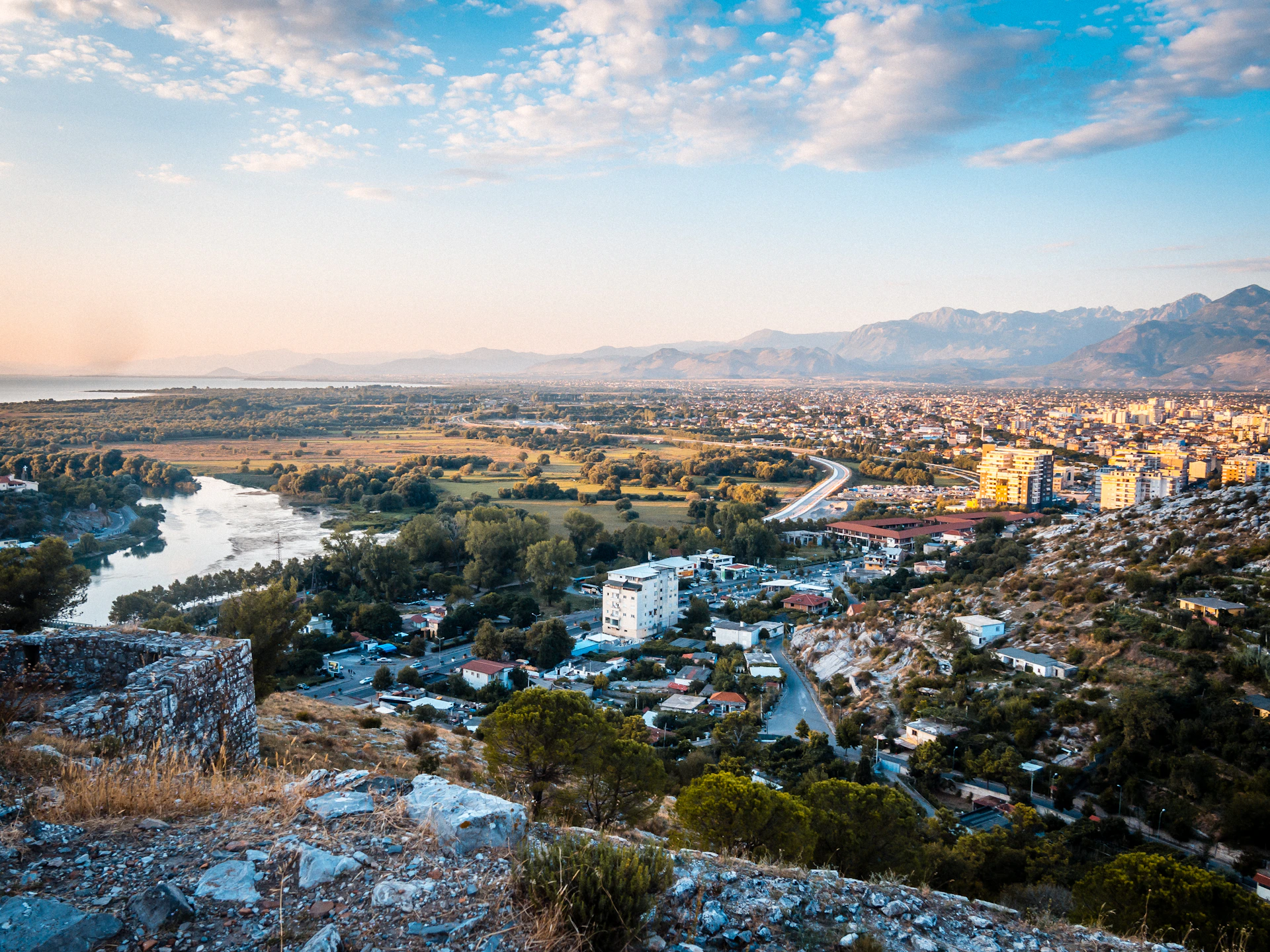 Shkodër and its surrounding river landscape beneath a blue sky