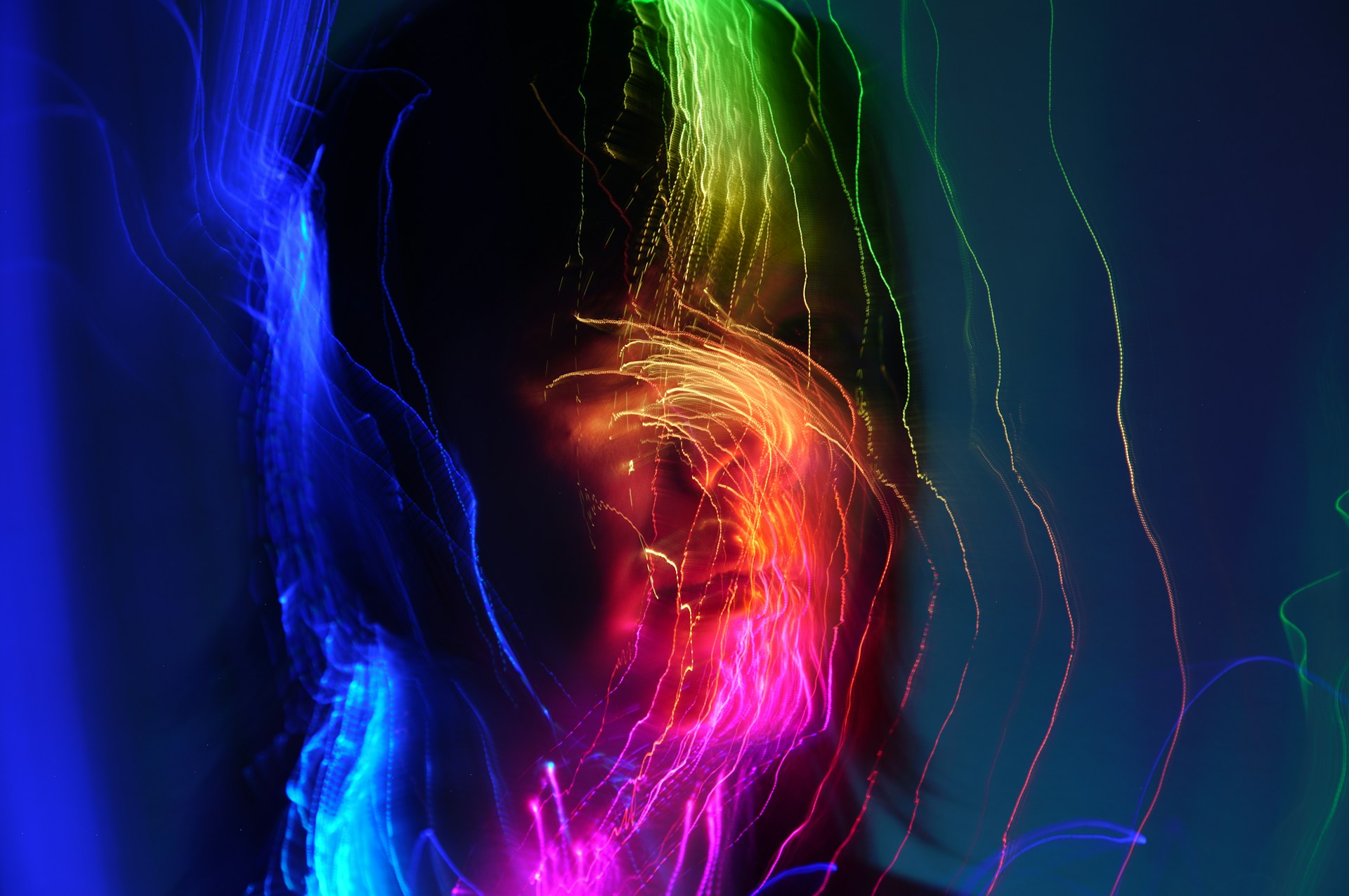 A person is covered in colorful light streaks.