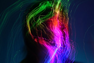 A person's face surrounded by colorful light trails.