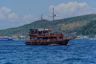 A pirate ship sails across the blue ocean.