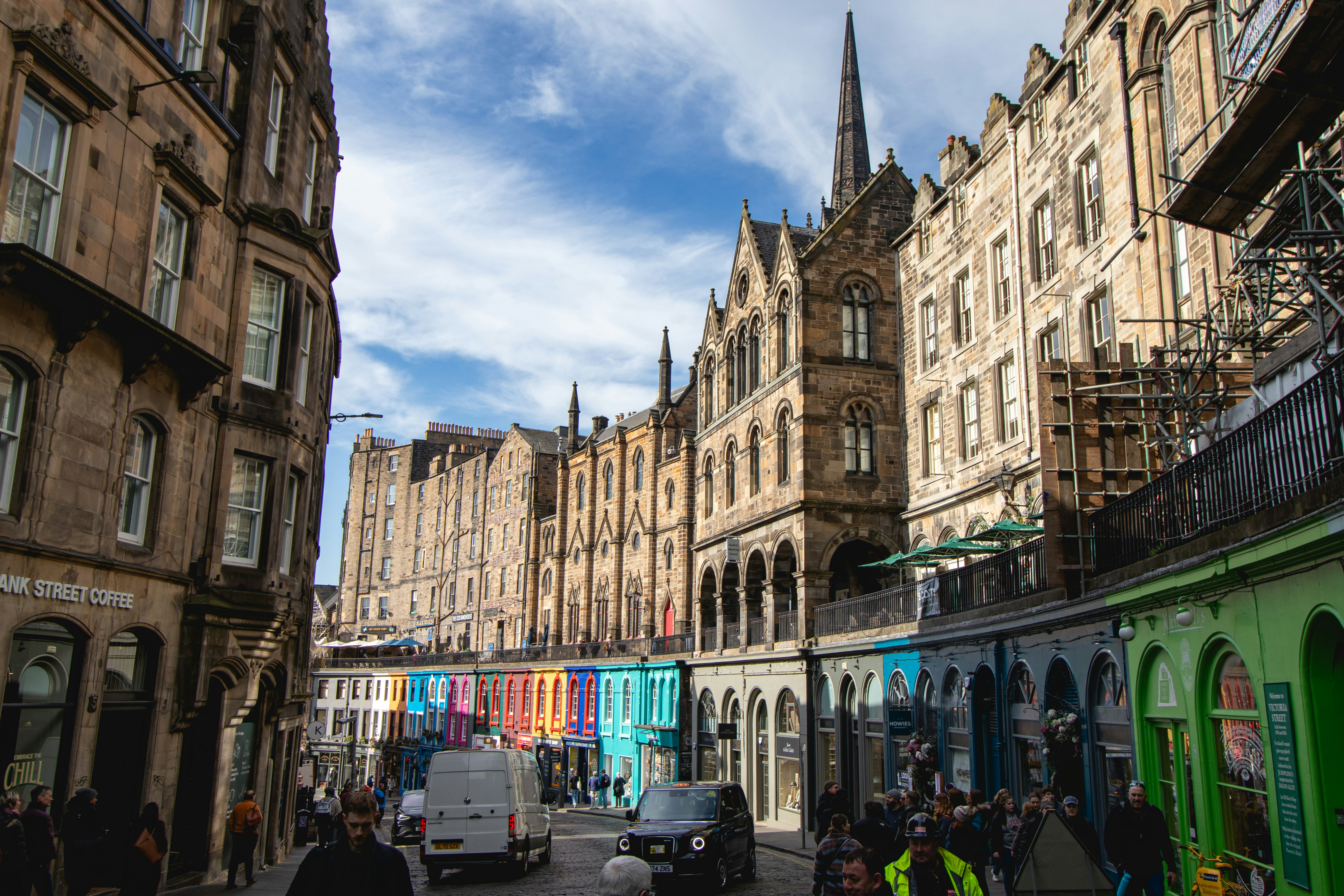 Historic buildings and colorful storefronts line the street.