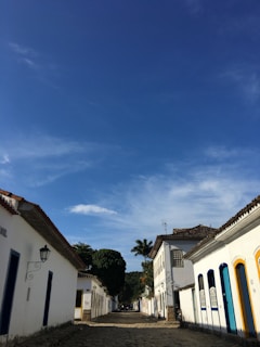 Historic street with white buildings and blue sky.