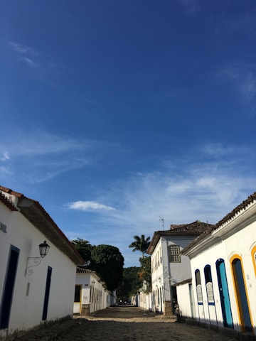 Historic street with white buildings and blue sky.