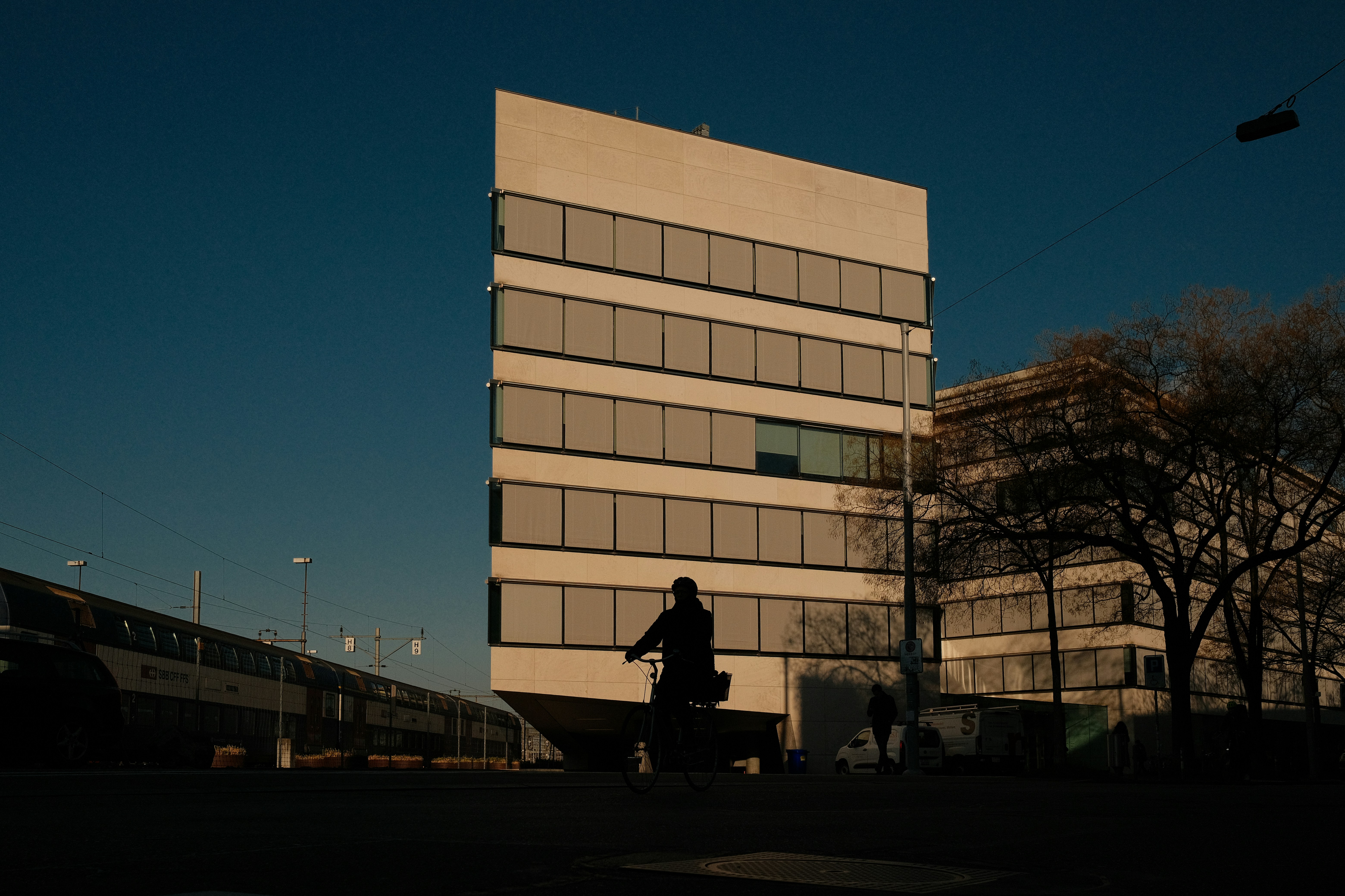A person walks in front of a modern building.
