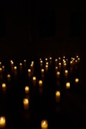 Candles illuminate a dark room.