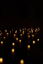 Candles illuminate a dark room.