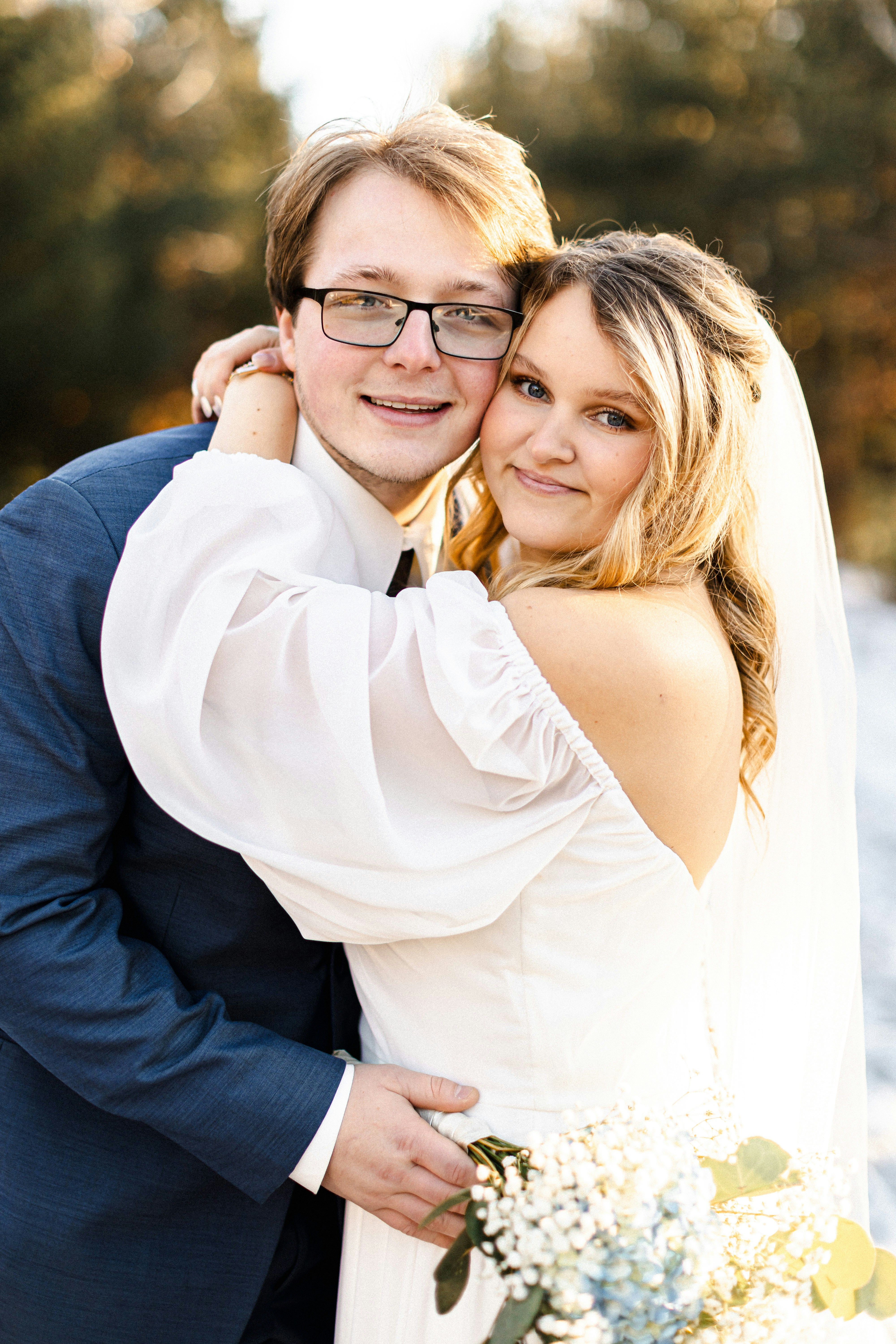 Newlyweds embrace and smile for a wedding photo.
