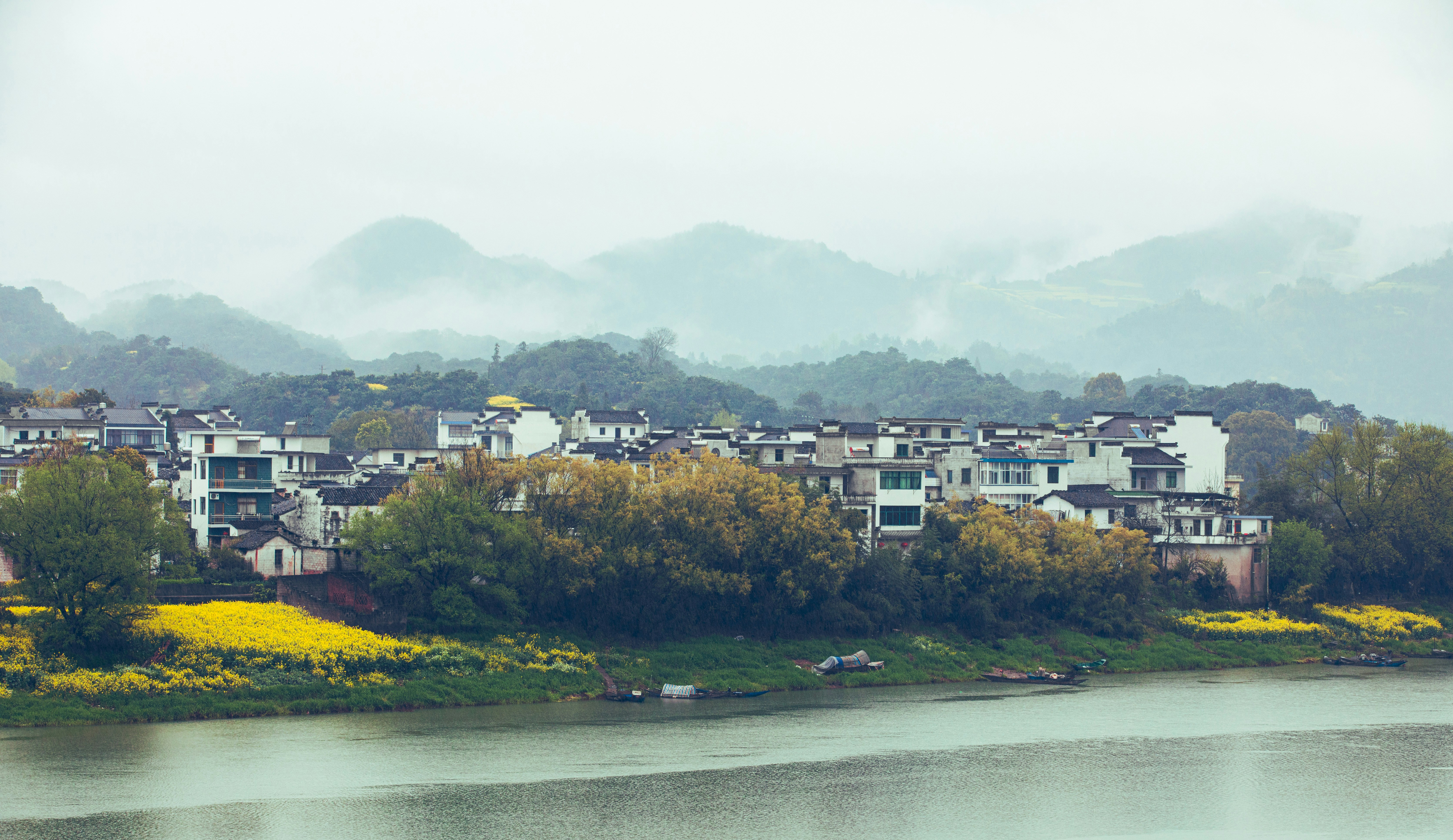 A village sits by a river and mountains.