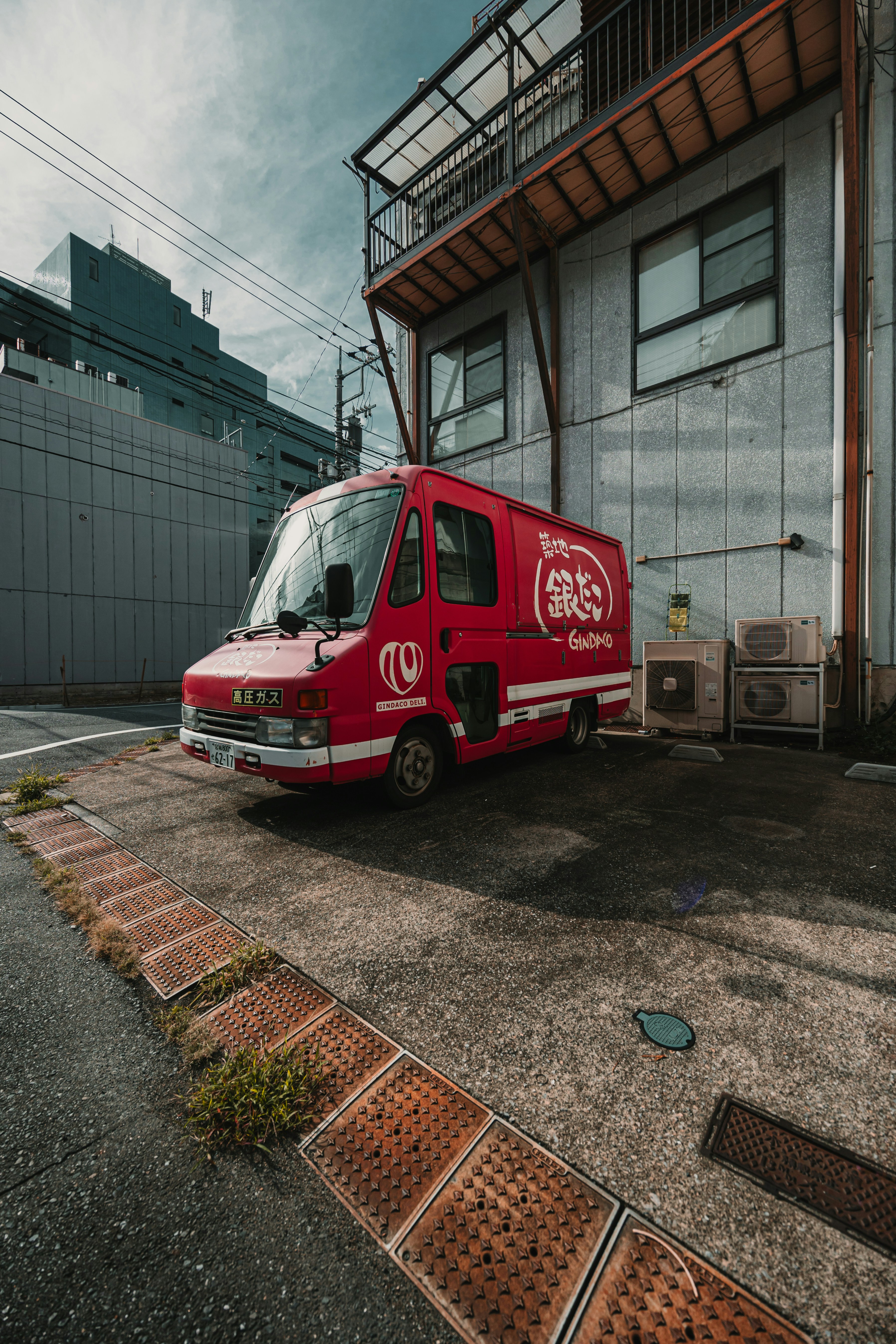Red food truck parked near a building.