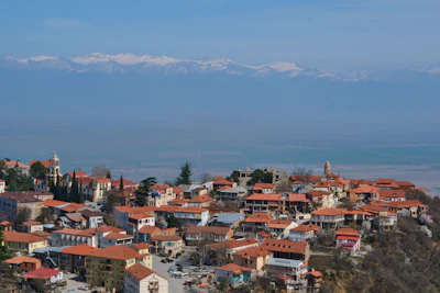 Sighnaghi’s terracotta roofs above the Alazani valley, the Caucasus along the horizon