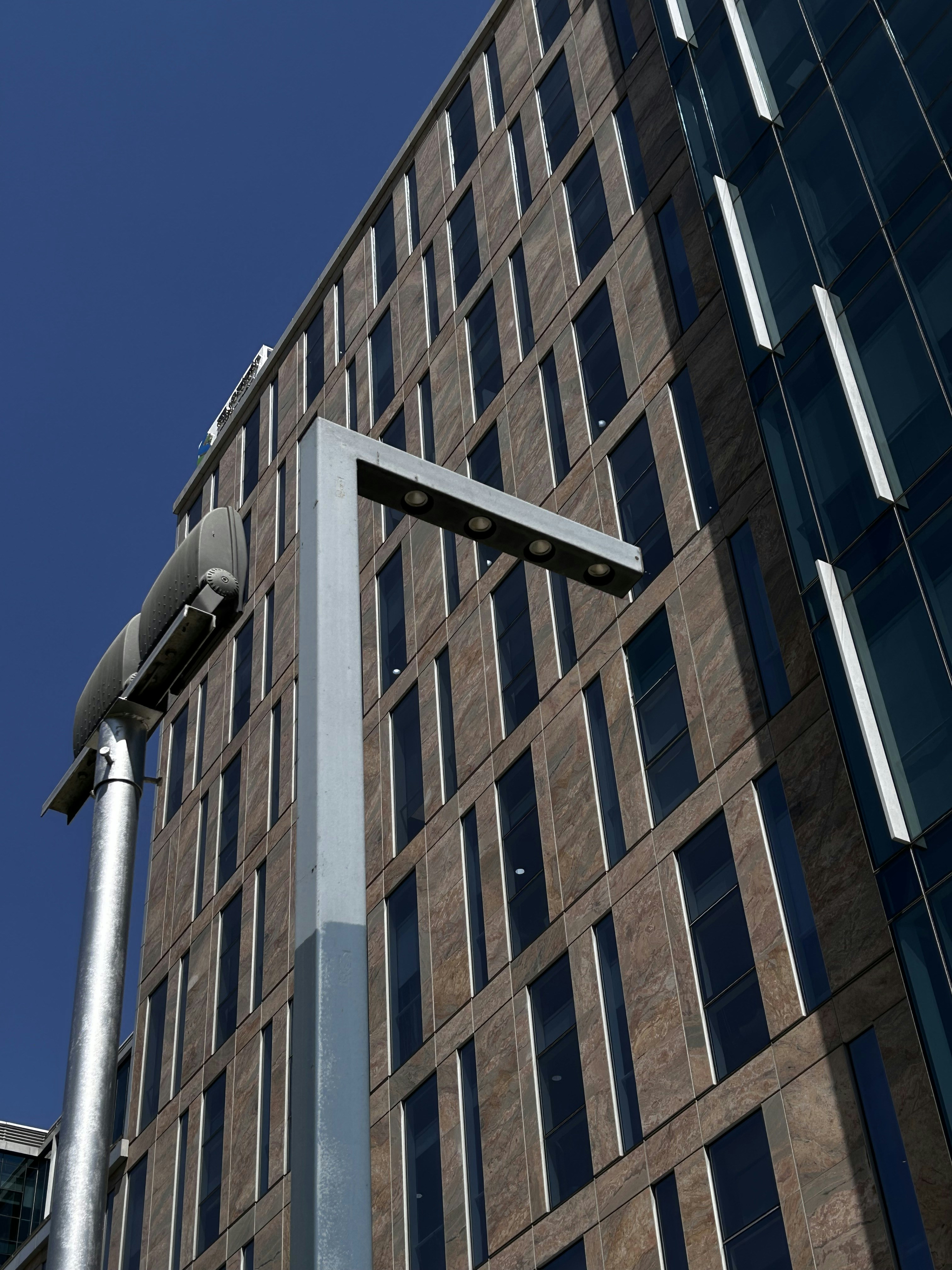 Modern skyscraper and street lamp against a blue sky.