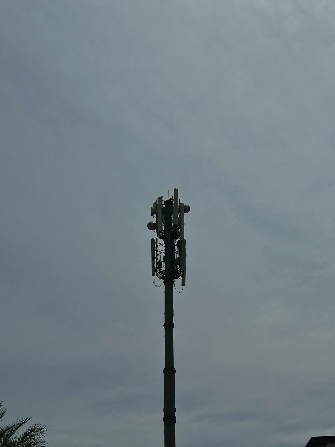 A cell tower against a cloudy sky.