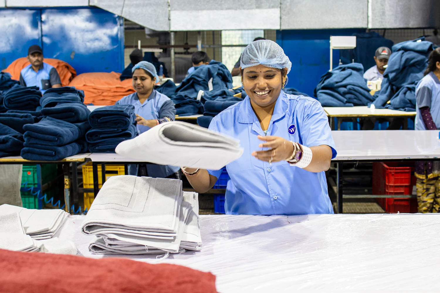 Laundry professionals folding and organizing fresh healthcare linens