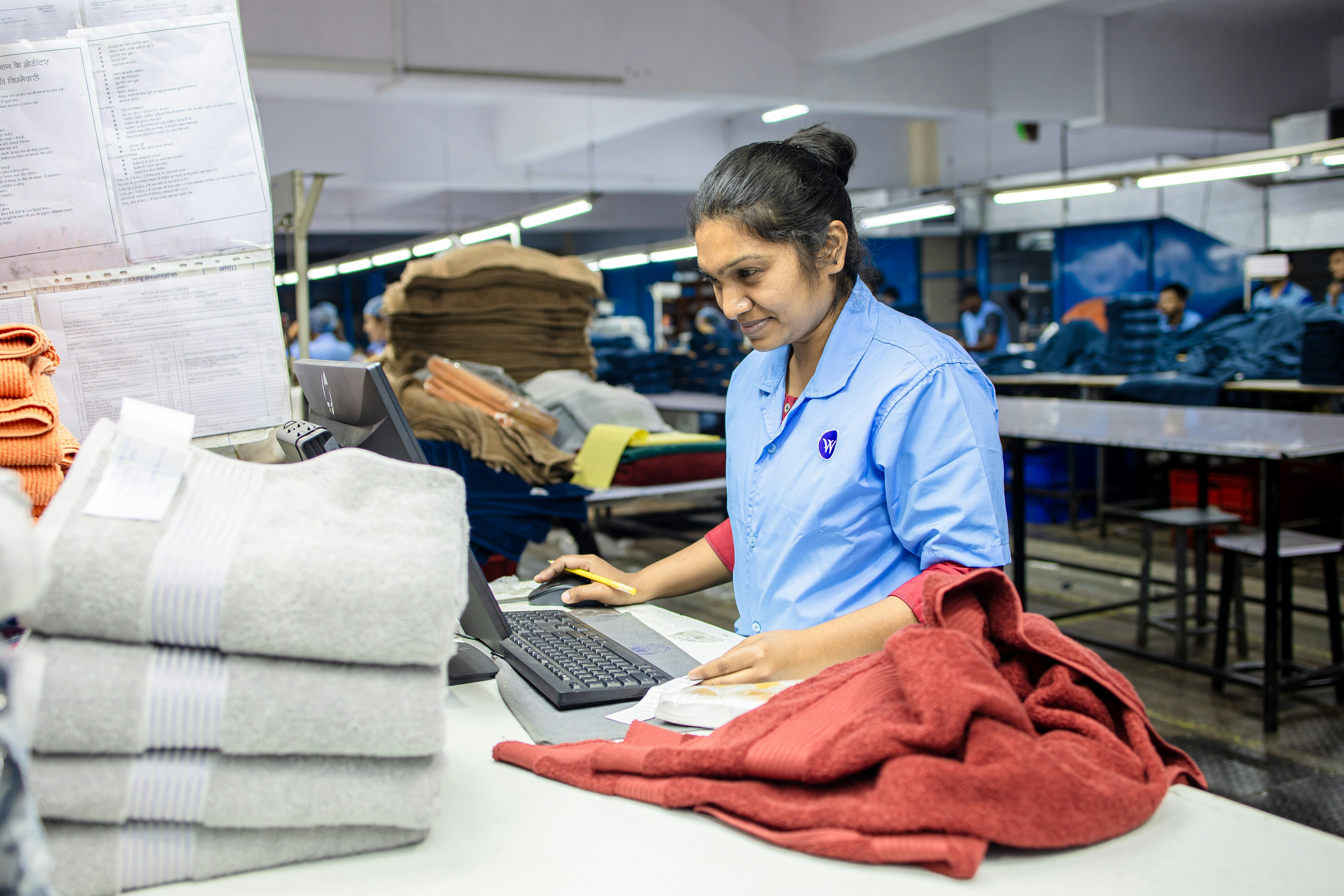 A factory worker processes inventory at her computer.