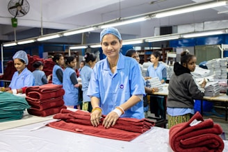 Textile workers are folding fabric in a factory.