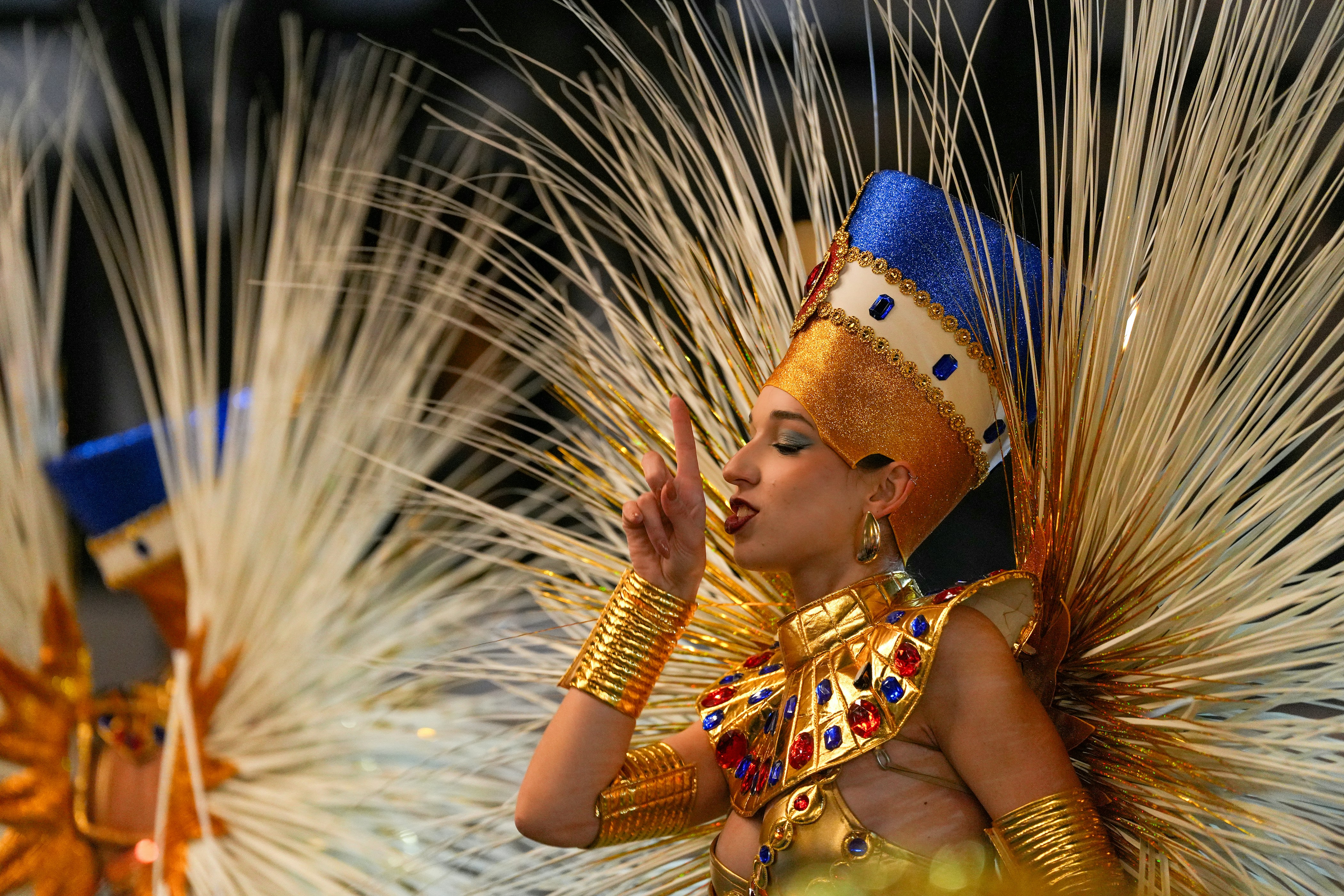 A woman in an egyptian-themed costume gestures.