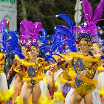 Carnival dancers parade in vibrant costumes.