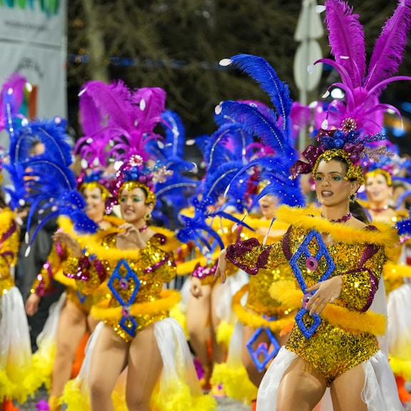 Carnival dancers parade in vibrant costumes.