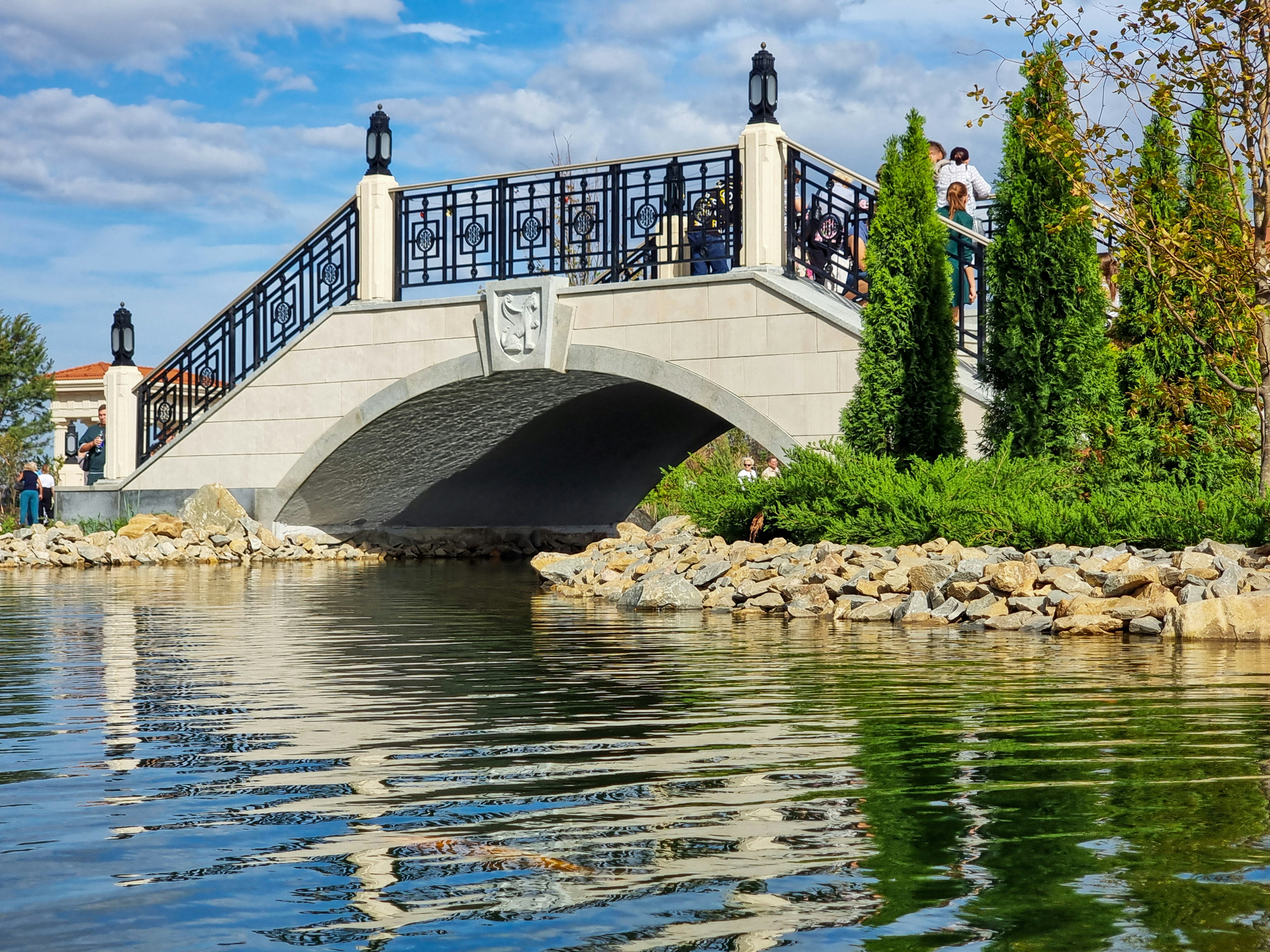 Un hermoso puente se extiende sobre aguas tranquilas y reflectantes.