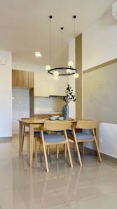 A modern dining room with a kitchen in the back.
