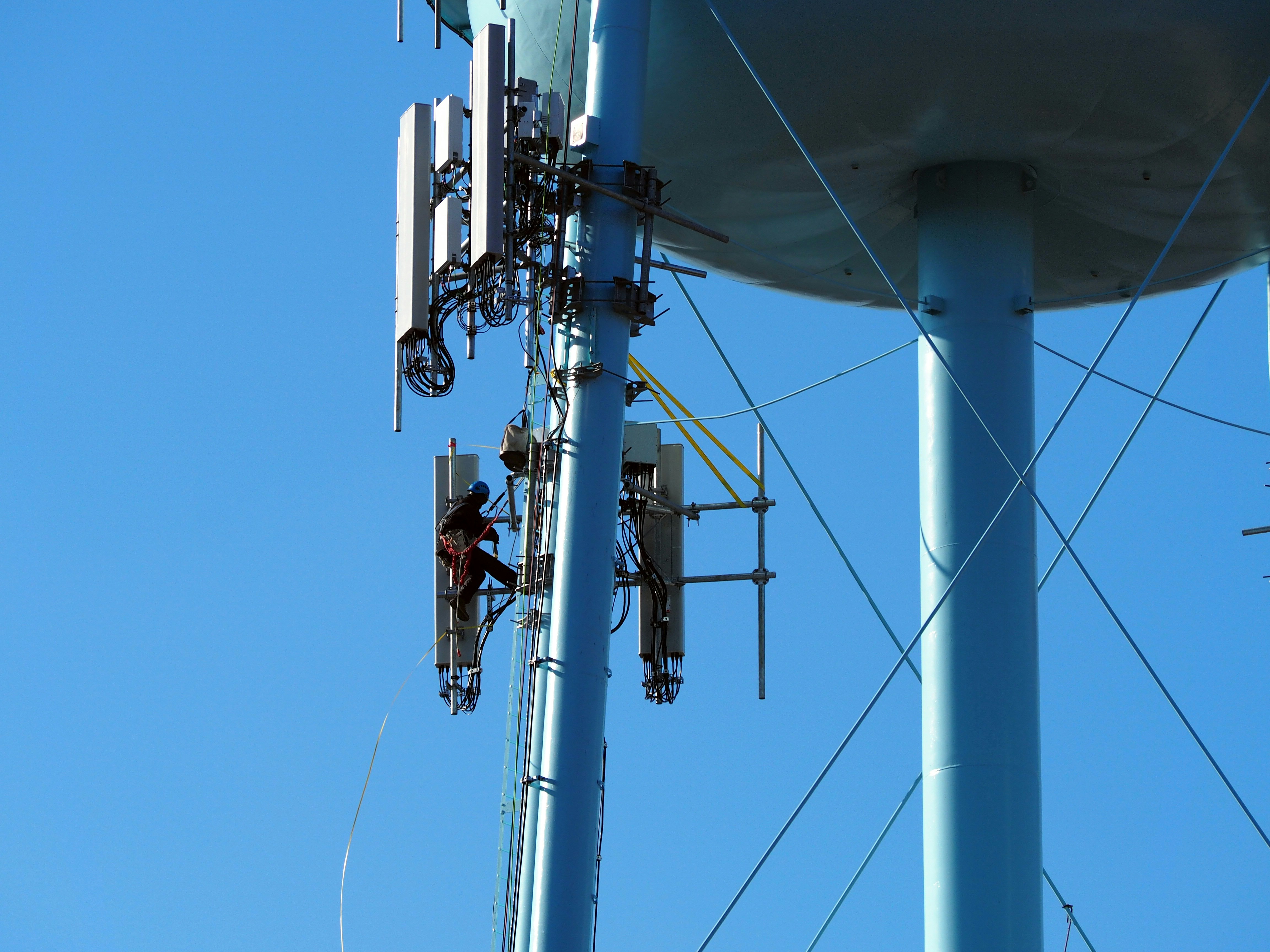 A worker repairs equipment on a water tower.