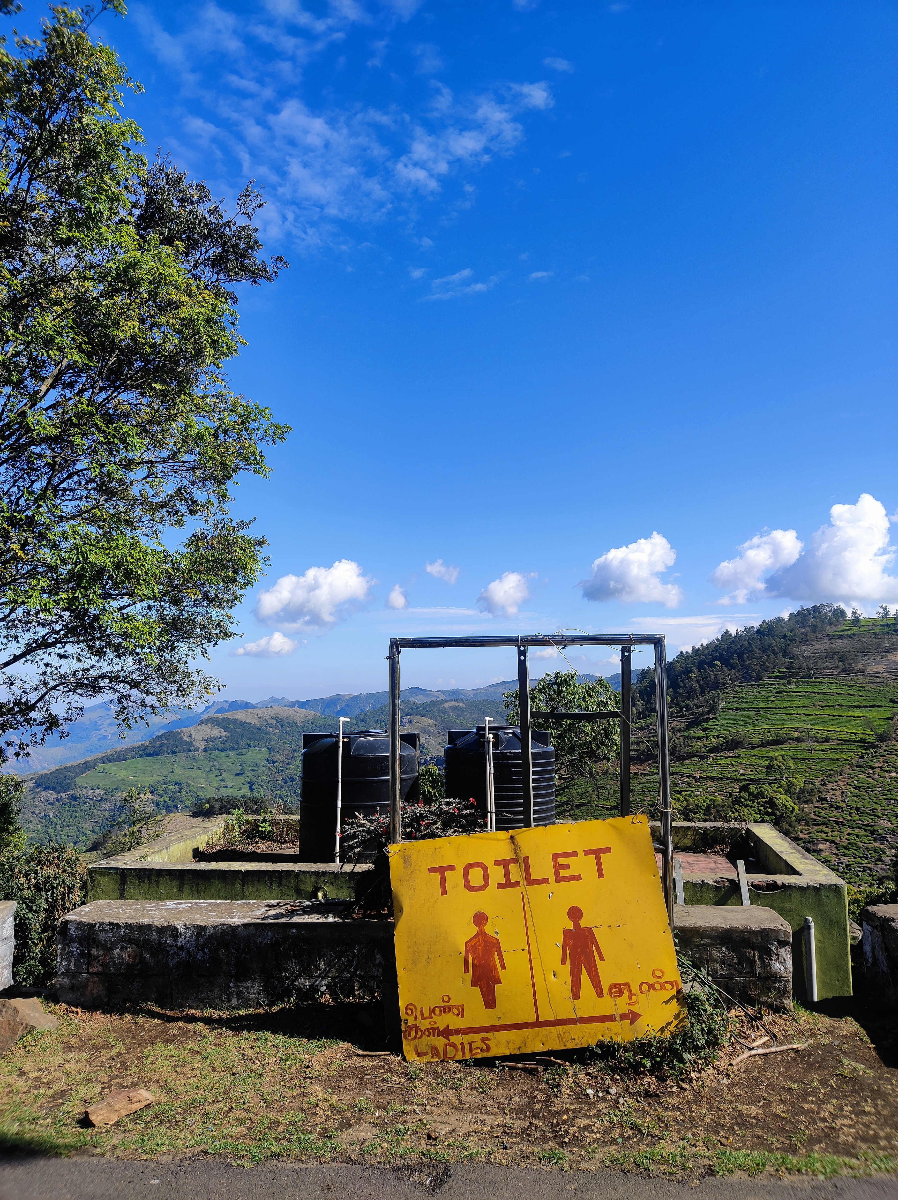 Un cartello della toilette si staglia su uno sfondo panoramico.