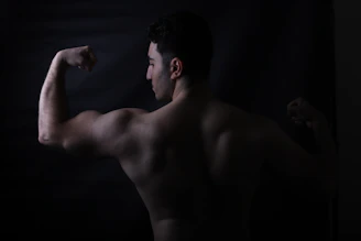 A bodybuilder flexes his biceps for the camera.