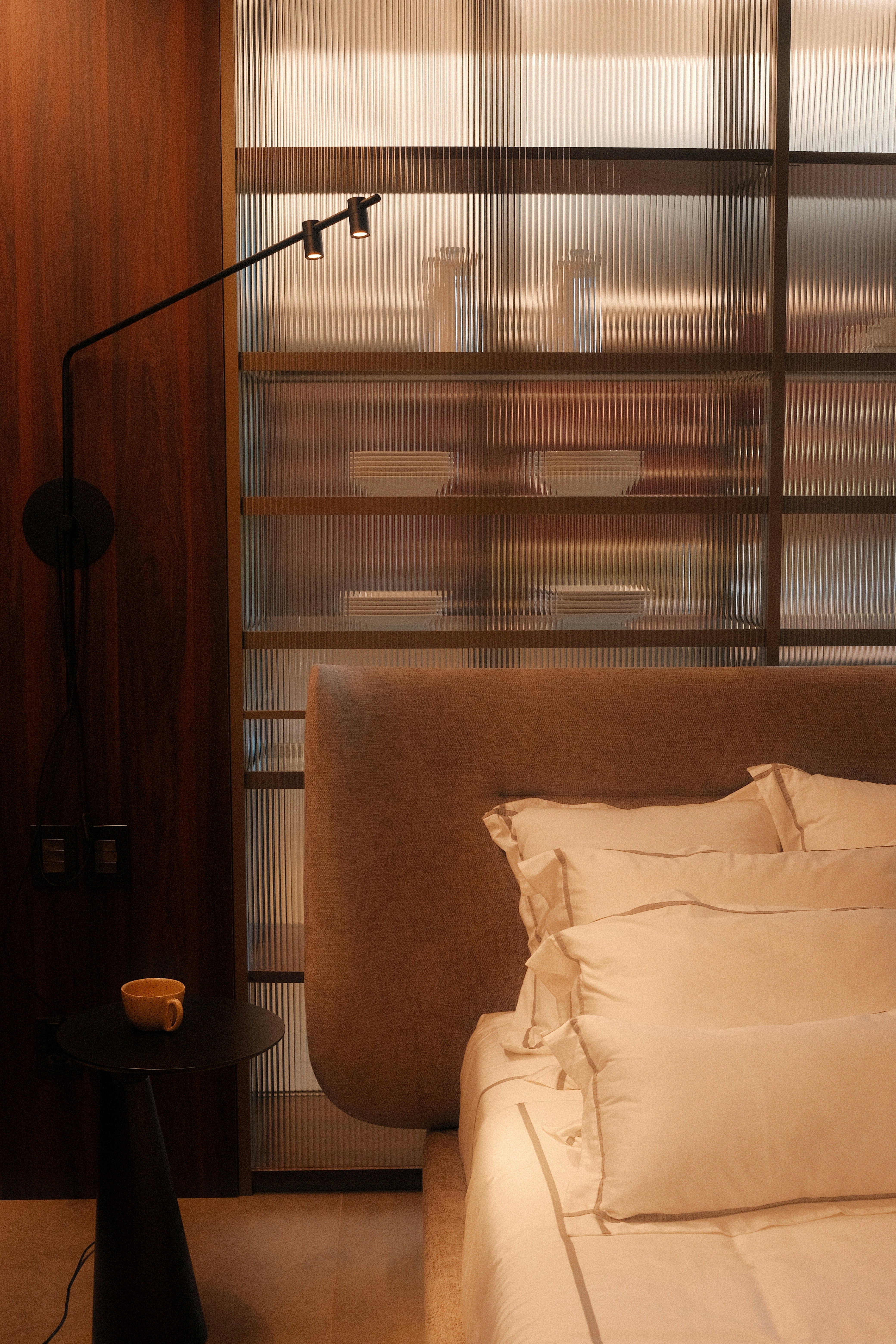 Modern bedroom with a stylish shelf and lamp.