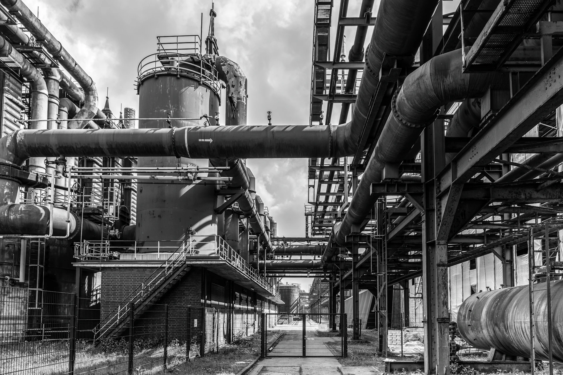 Industrial pipes and structures fill the image