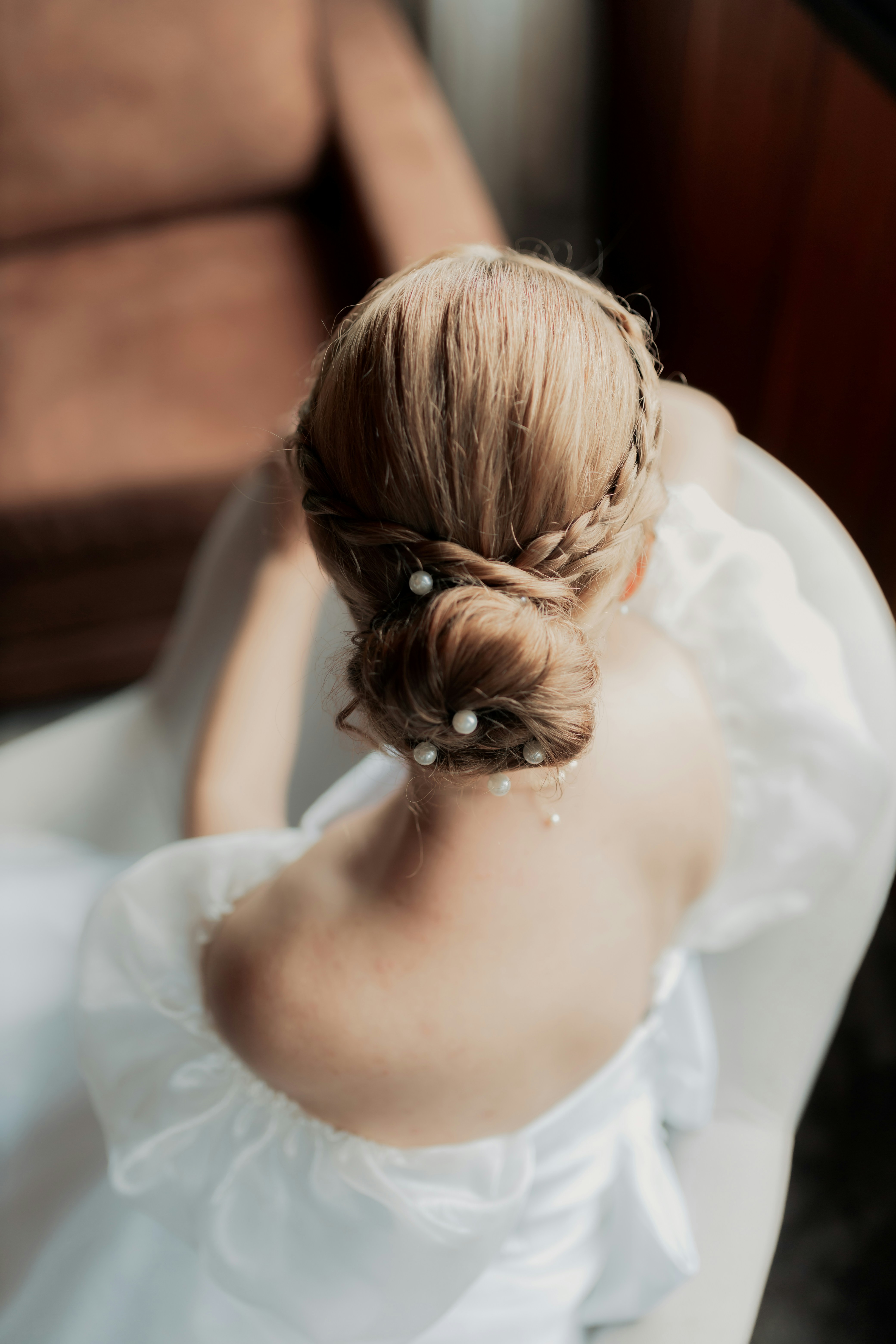 O cabelo de uma noiva penteado em um penteado elegante.
