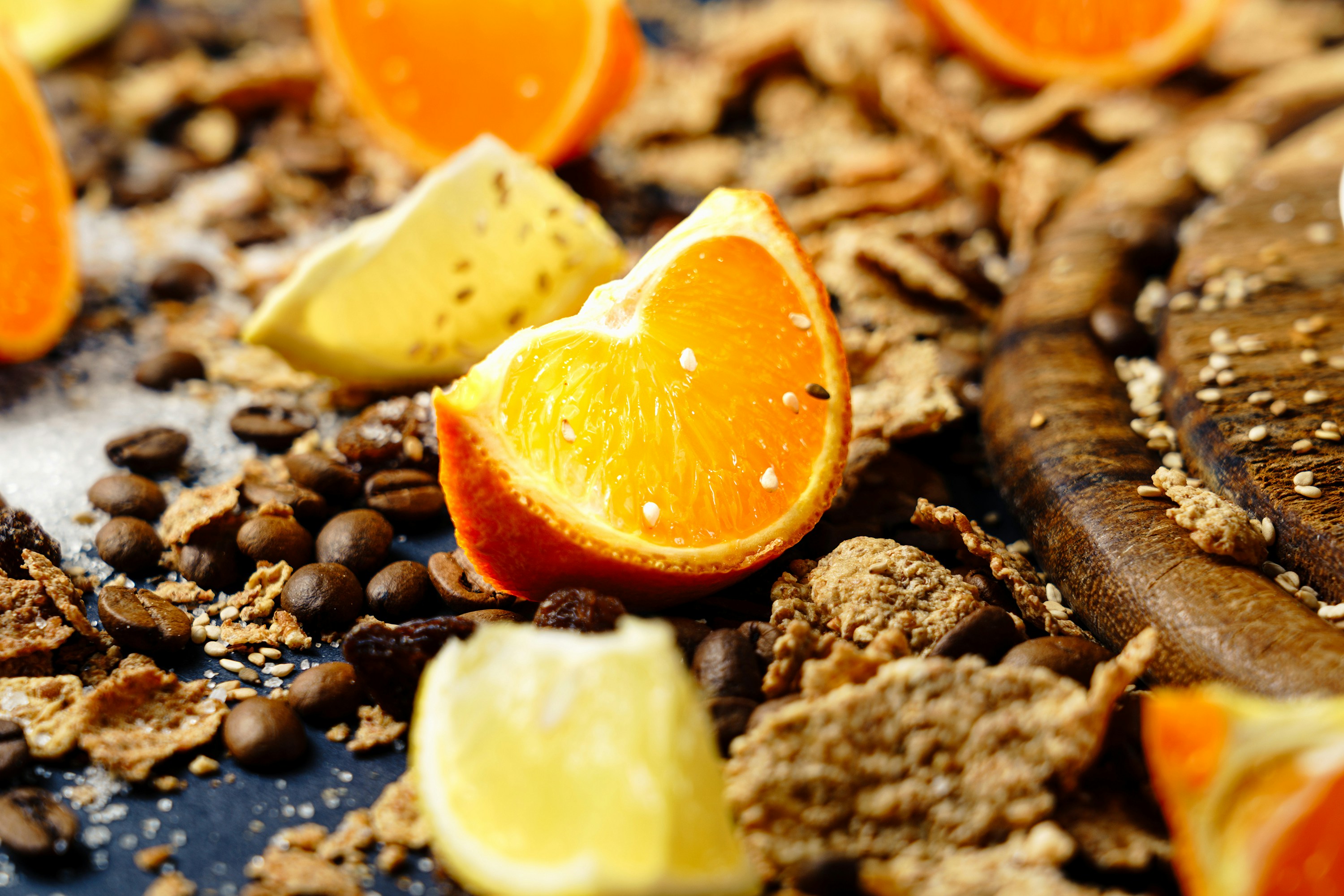 Orange slices sit among coffee beans and cereal.