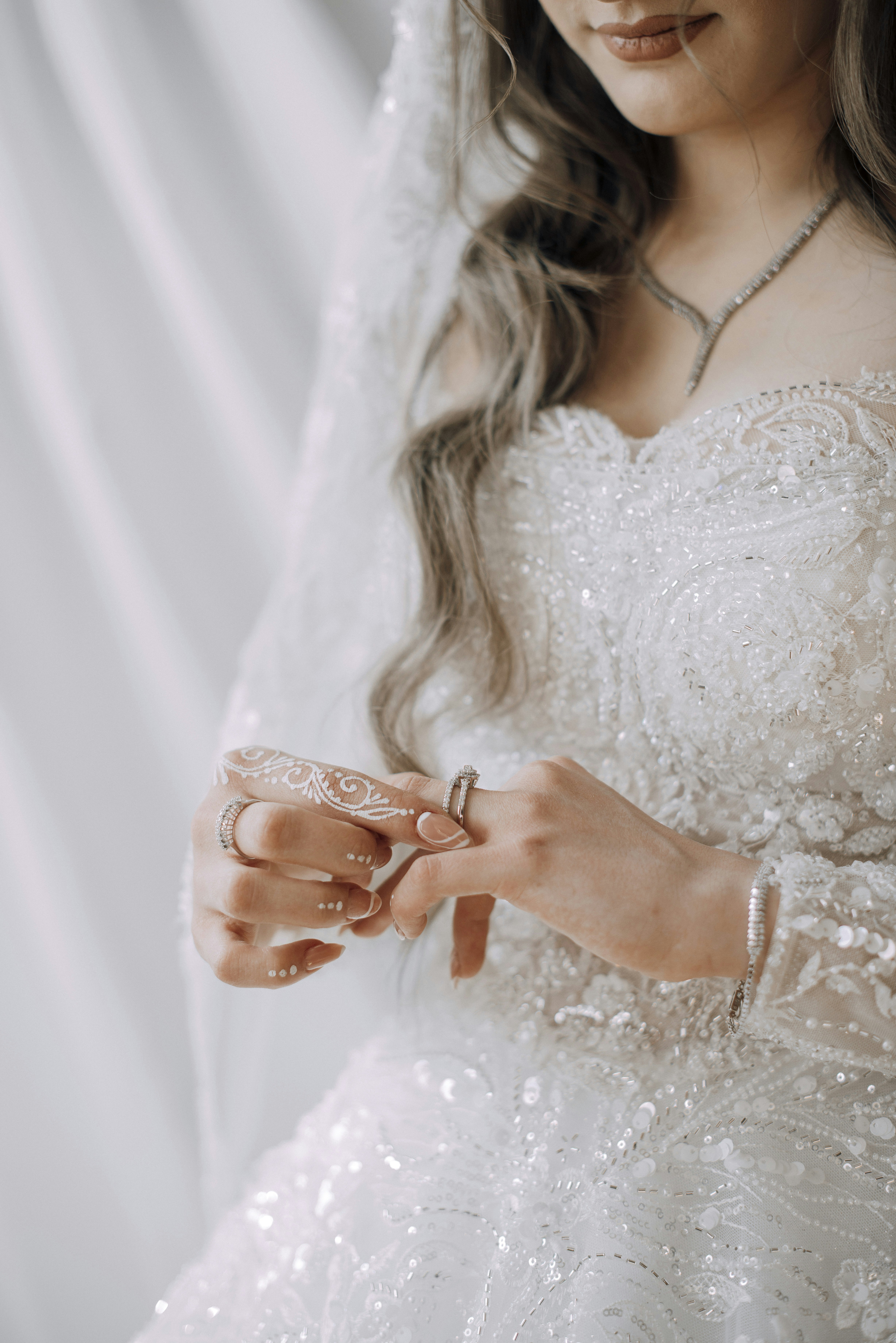 A bride is adjusting her rings on wedding day.