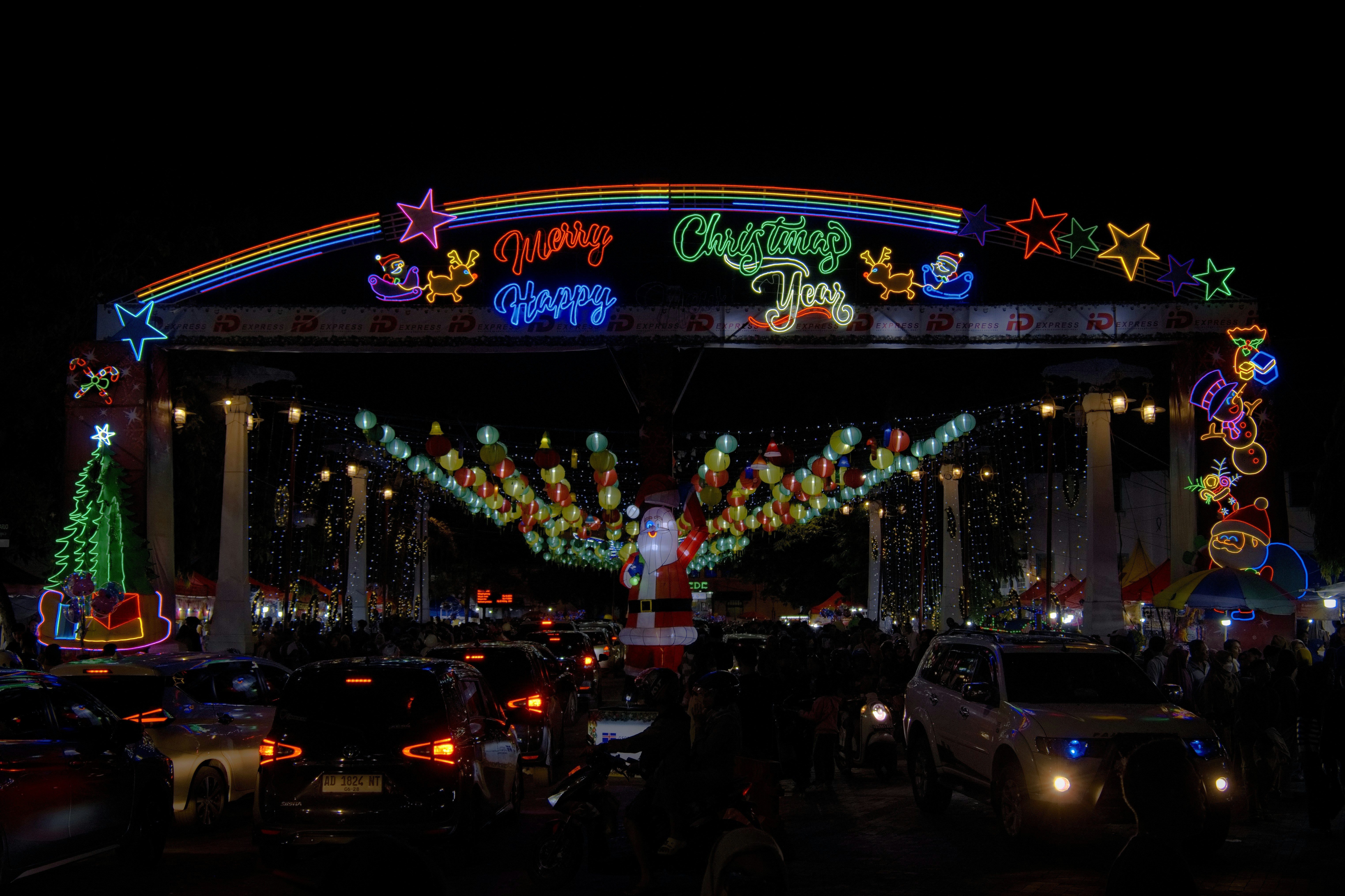 Christmas lights illuminate a festive archway at night.