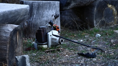 A broken chainsaw lies on the ground.