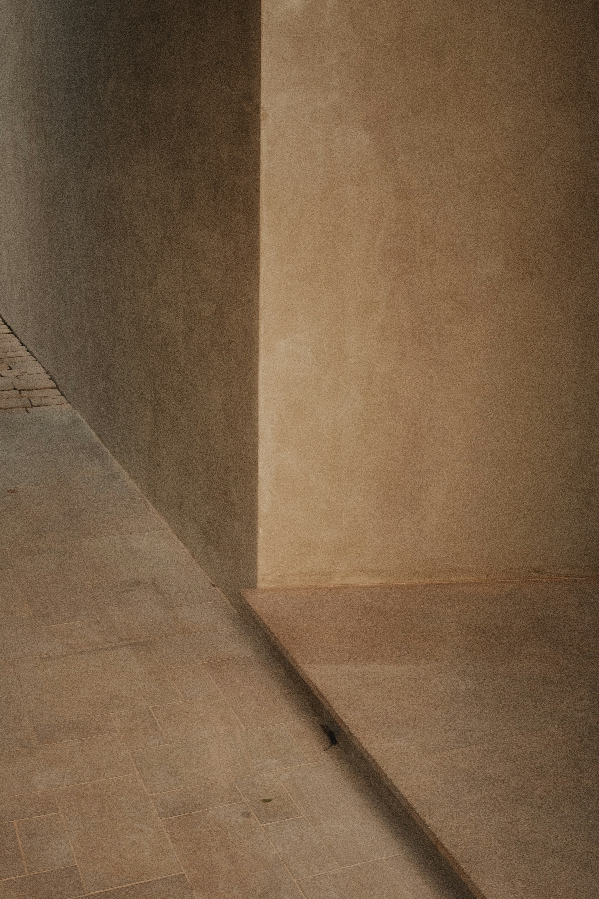 Walls and floors in a beige-toned architectural space.