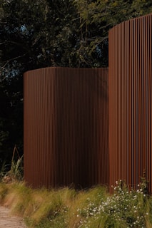 Brown, modern architectural structures are nestled in the green.