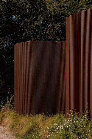 Brown, modern architectural structures are nestled in the green.