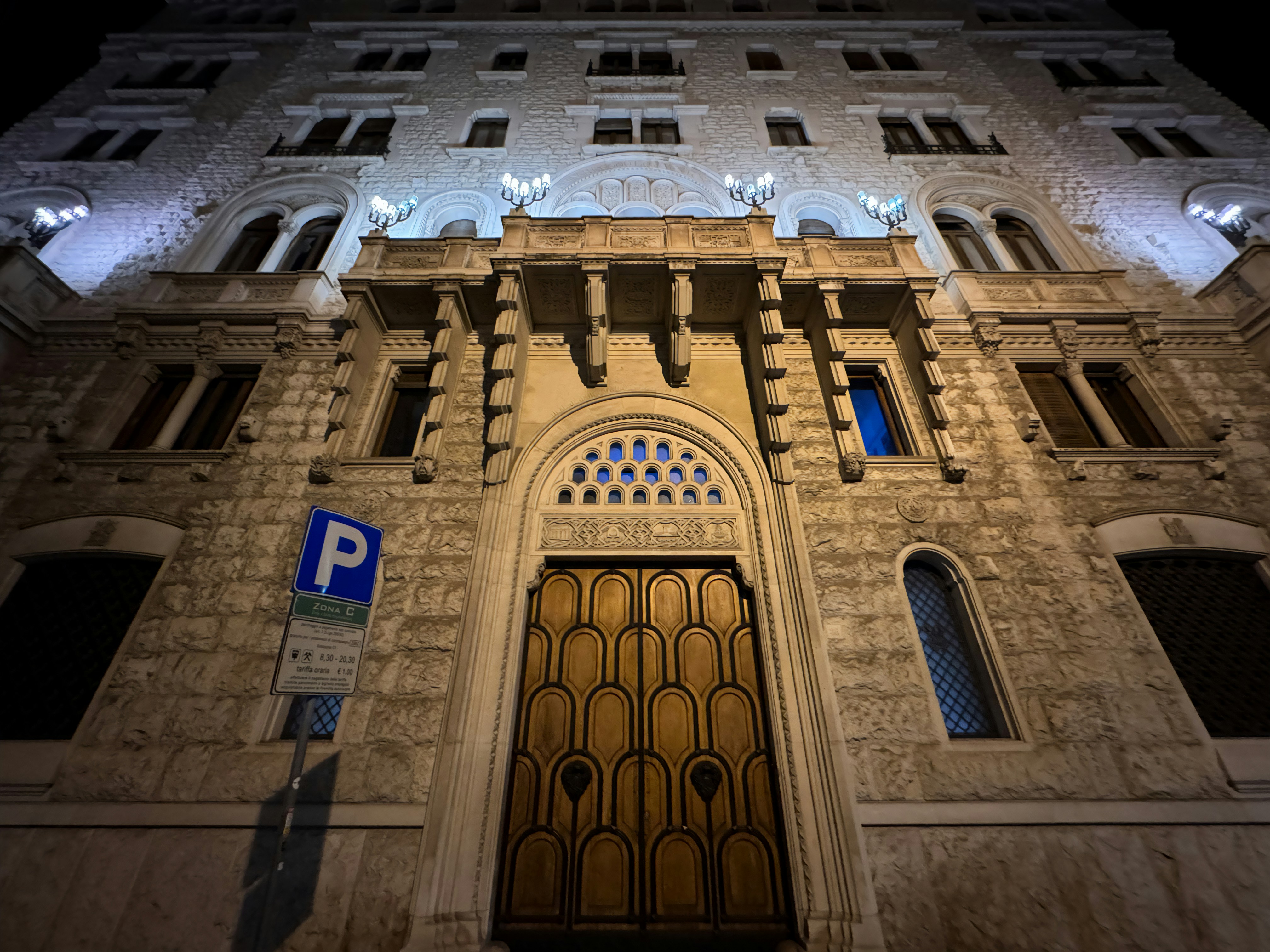 Historic building entrance lit up at night.