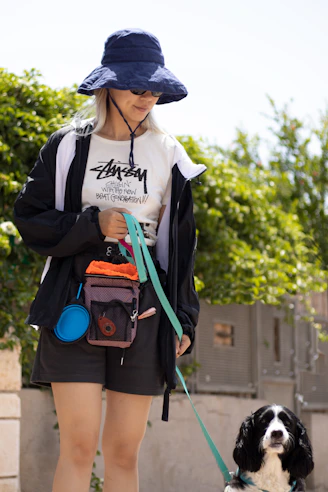 Woman walks a dog in the sunshine.