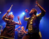 Musicians enthusiastically perform on stage.
