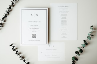 Wedding invitations and stationery displayed with greenery.